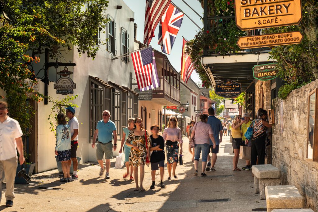 People walk along the shops and restaurants of Saint George street in the historic district of St. Augustine Florida