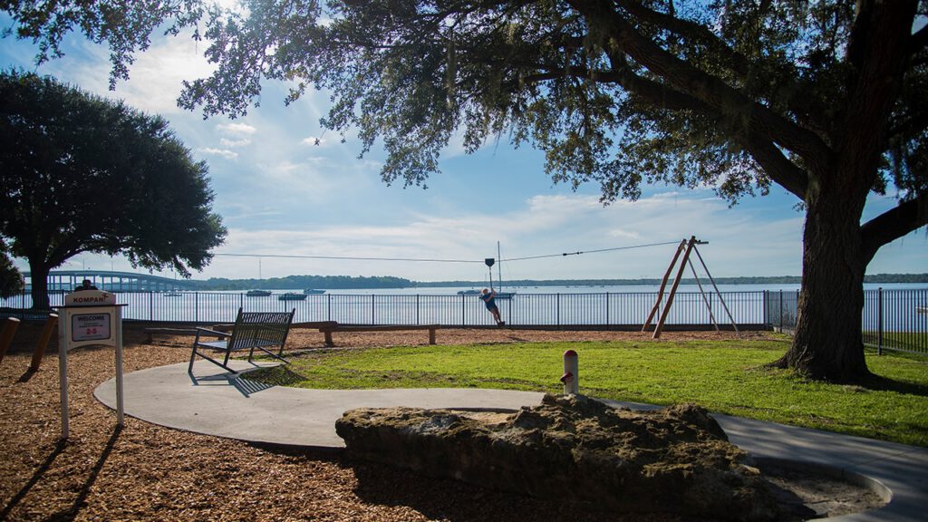 A child ziplines along a beachside playground.