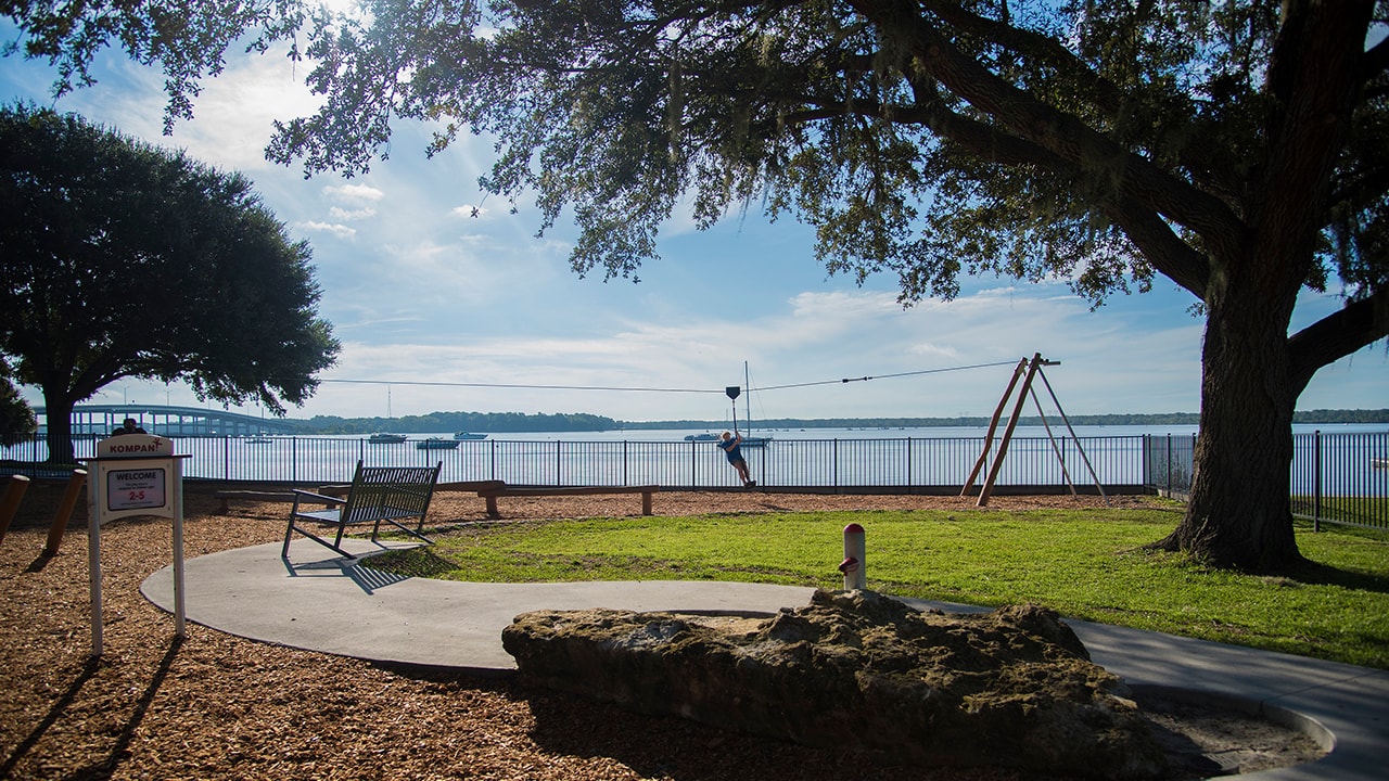 A child ziplines along a beachside playground.