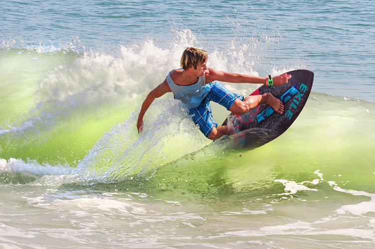 Boy skimboarding on the Atlantic Ocean