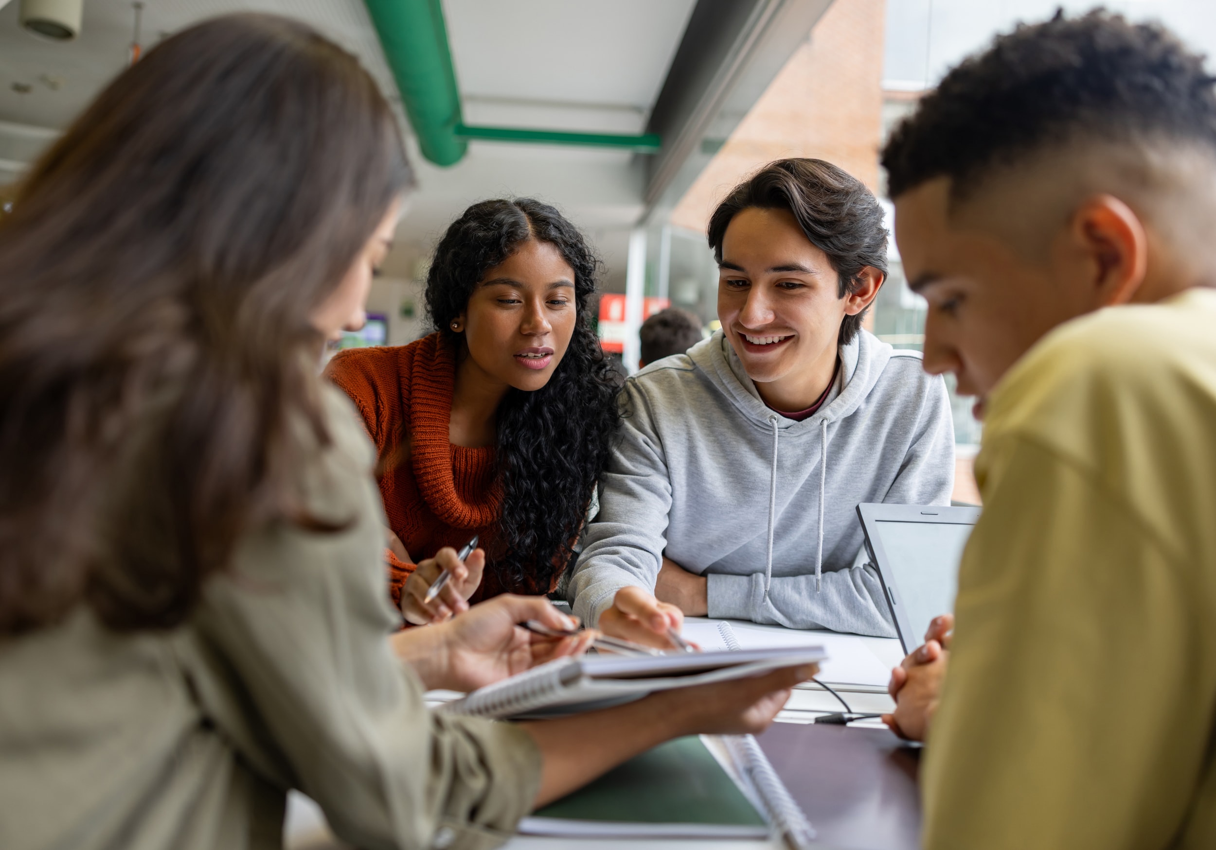 Happy group of students studying together at a library.